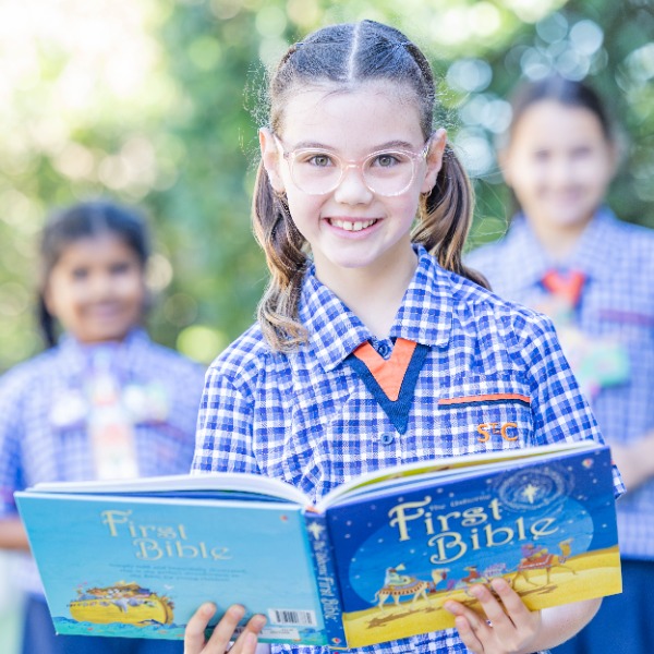 Student holdinga  book smiling